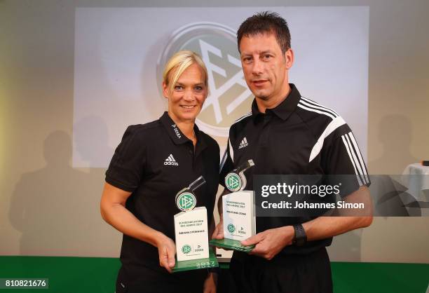 Referees Bibiana Steinhaus and Wolfgang Stark pose with the award trophy after been awarded as referee of the year 2017 on July 8, 2017 in Grassau,...