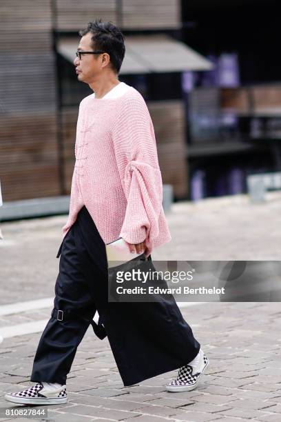 Guest wears a pink large wool top, black large pants, checkered sneakers, glasses, during Paris Fashion Week - Haute Couture Fall/Winter 2017-2018,...