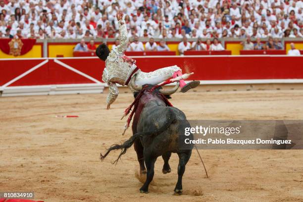 Bull from Jose Escolar Gil's fighting bulls tosses Spanish bullfighter Gonzalo Caballero during a bullfight on the third day of the San Fermin...