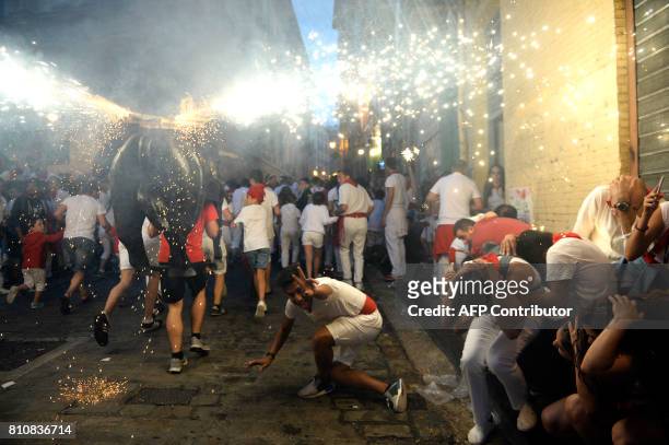 Man incarnating a "Toro de Fuego" chases people during the San Fermin Festival on July 8 in Pamplona, northern Spain. Pamplona is host to the most...