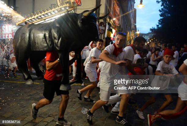 Man incarnating a "Toro de Fuego" chases people during the San Fermin Festival on July 8 in Pamplona, northern Spain. Pamplona is host to the most...