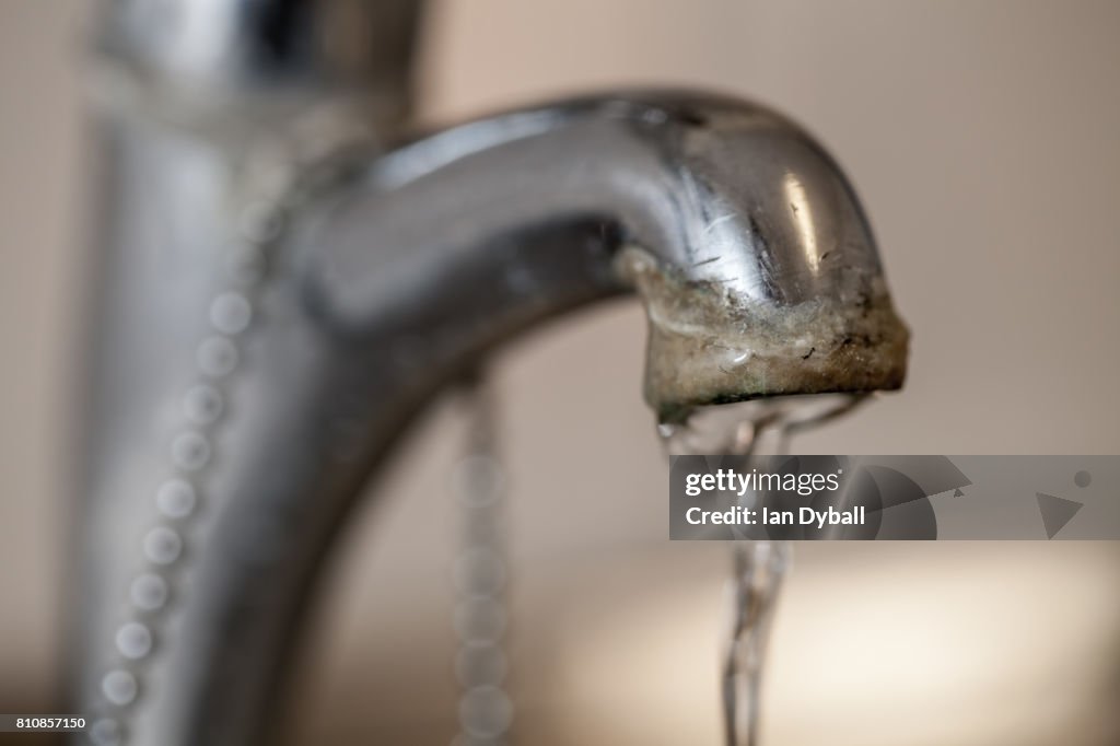 Tap limescale. Selective focus on the hard water deposit of a running kitchen faucet.