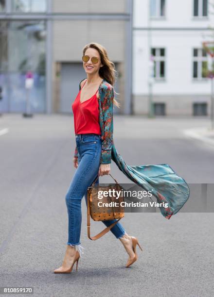 Model and fashion blogger Alexandra Lapp wearing a wrap dress in Kimono style from Zara, silk tank top from Jadicted, petite bucket bag from MCM,...