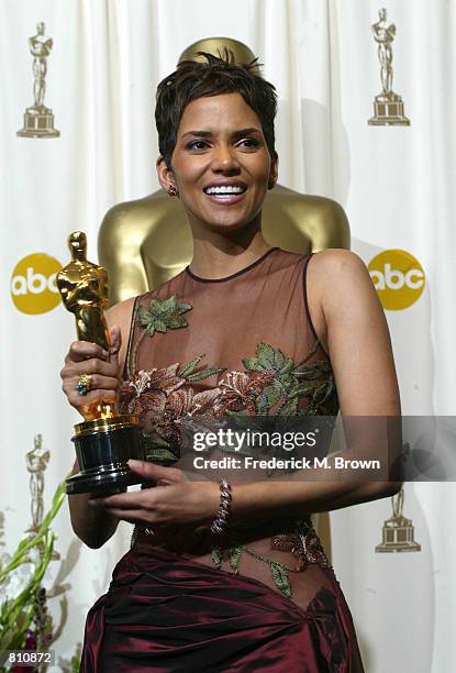 Actress Halle Berry poses with her Best Actress in a Leading Role Oscar for "Monster's Ball" backstage during the 74th Annual Academy Awards March...