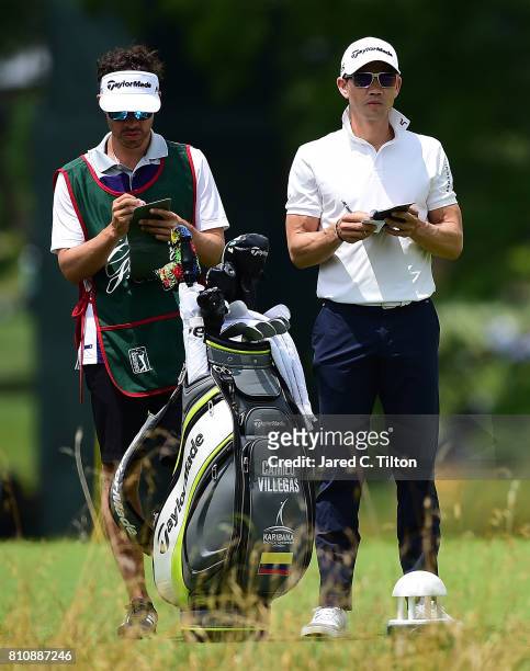 Camilo Villegas of Colombia stands with his caddie on the third tee during round three of The Greenbrier Classic held at the Old White TPC on July 8,...
