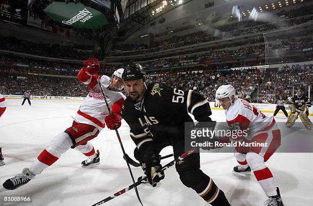 Defenseman Sergei Zubov of the Dallas Stars works the puck on the boards against Dan Cleary and Jiri Hudler of the Detroit Red Wings during game four...