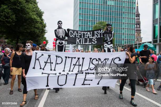 People holding a banner reading 'capitalism kills' attend a protest march against the G20 Summit with the topic 'Solidarity without borders instead...