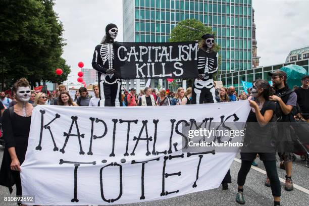 People holding a banner reading 'capitalism kills' attend a protest march against the G20 Summit with the topic 'Solidarity without borders instead...