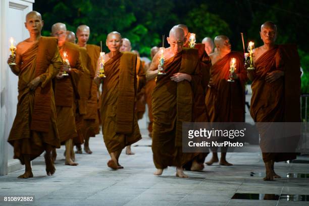 Thai monks hold candles and incense they perform during a ceremony marking Asalha Puja Day in Wat Asokaram Samut Prakan, Thailand, 8 July 2017....