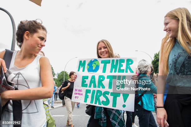 Woman holding a banner reading 'mother earth first' attends a protest march against the G20 Summit with the topic 'Solidarity without borders instead...