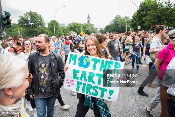 Woman holding a banner reading 'mother earth first' attends a protest march against the G20 Summit with the topic 'Solidarity without borders instead...
