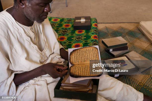 NA manuscripts expert holds a manuscript that was burn by the Islamist rebels at the Ahmed Baba Institute on August 12, 2013 in Timbuktu, Mali"nIn...