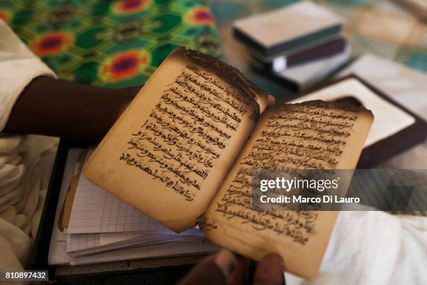 NA manuscripts expert holds a manuscript that was burn by the Islamist rebels at the Ahmed Baba Institute on August 12, 2013 in Timbuktu, Mali"nIn...