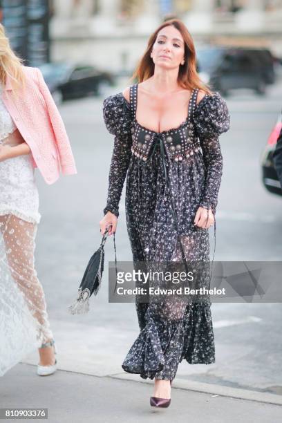 Guest wears a black lace mesh dress, a bag with fringes, purple heels shoes, outside the amfAR dinner at Petit Palais, during Paris Fashion Week -...