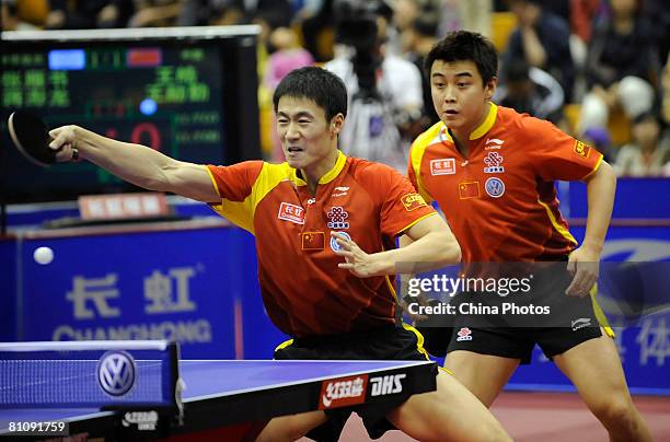 Liqin Wang and Wang Hao of China hits a shot against Chang Yen-shu and Chiang Peng-Lung of Taipei in the first round of the Men's Team Competition on...