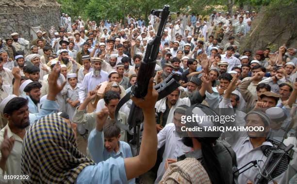 Pakistani alleged Taliban supporters chant anti-US slogans as they gather at the site of a US missile strike in Damadola village in the northwestern...