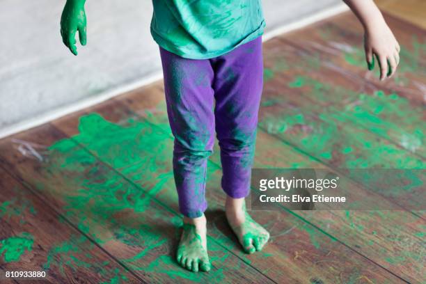 spilled green paint on a child and wooden floor - misbehaving children stock pictures, royalty-free photos & images