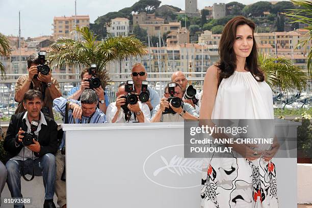 Actress Angelina Jolie cradles her baby bump as she poses during a photocall for US directors John Stevenson and Mark Osborne animated film 'Kung Fu...