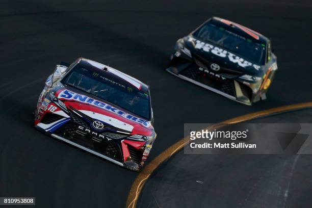 Kyle Busch, driver of the Snickers Toyota, leads Martin Truex Jr., driver of the Furniture Row/Denver Mattress Toyota, during the Monster Energy...