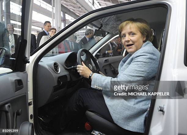 German Chancellor Angela Merkel inspects a Volkswagen car during a visit to the VW plant in Sao Bernardo do Campo, southern Sao Paulo on May 15,...