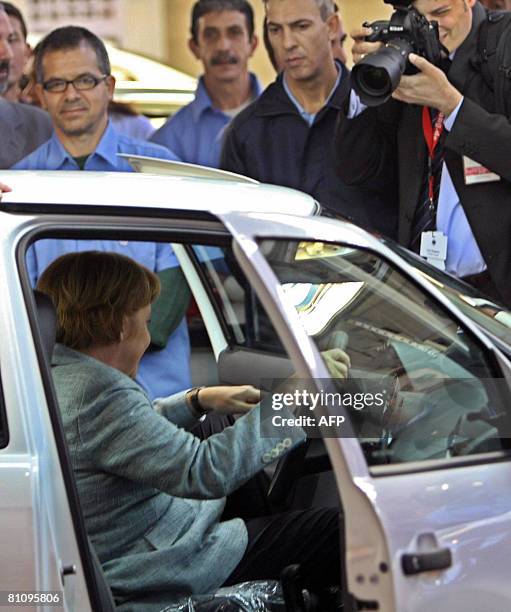 German Chancellor Angela Merkel checks a car during her visit to the VW plant, on May 15 in Sao Bernardo do Campo, southern Sao Paulo, Brazil. Merkel...