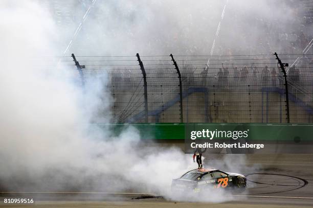 Martin Truex Jr., driver of the Furniture Row/Denver Mattress Toyota, celebrates with a burnout after winning the Monster Energy NASCAR Cup Series...