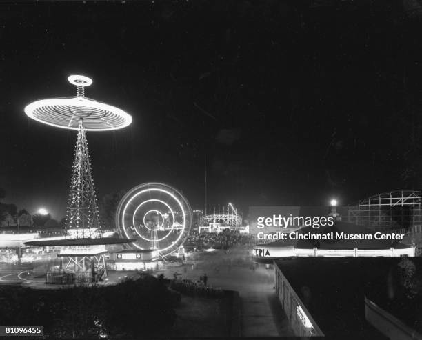 Night time view of the bright lights of the amusement park rides at Coney Island Park, Cincinnati, Ohio, 1940s.