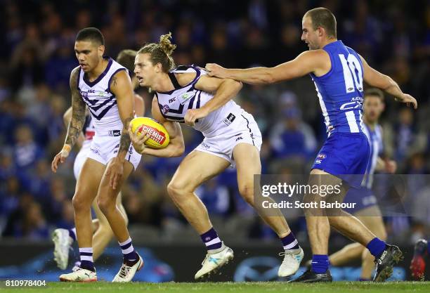 Nat Fyfe of the Dockers is tackled by Ben Cunnington of the Kangaroos during the round 16 AFL match between the North Melbourne Kangaroos and the...