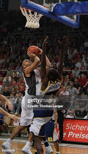 Ademola Okulaja of Bamberg scores against Rouben Boumtje Boumtje of Oldenburg during the Basketball Bundesliga quarter final play-off match between...