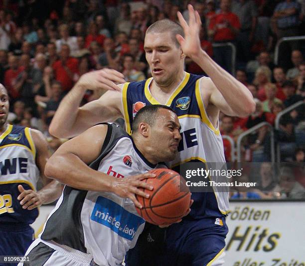 Dan McClintock of Oldenburg and Robert Garrett of Bamberg battle for the ball during the Basketball Bundesliga quarter final play-off match between...