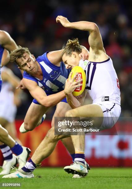 Nat Fyfe of the Dockers is tackled by Trent Dumont of the Kangaroos during the round 16 AFL match between the North Melbourne Kangaroos and the...