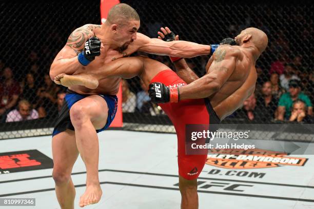 Robert Whittaker of New Zealand punches Yoel Romero of Cuba in their interim UFC middleweight championship bout during the UFC 213 event at T-Mobile...