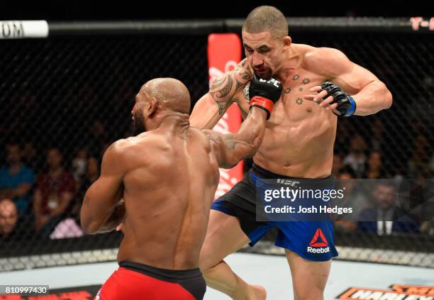 Yoel Romero of Cuba punches Robert Whittaker of New Zealand in their interim UFC middleweight championship bout during the UFC 213 event at T-Mobile...