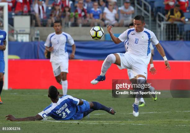 Nicaragua's Luis Galeano avoids the slide tackle attempt of Martinique's Sebastien Cretinoir during the CONCACAF Gold Cup Group B match on July 08,...