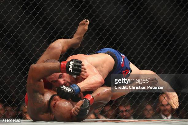 Robert Whittaker of New Zealand punches Yoel Romero of Cuba in their interim UFC middleweight championship bout during the UFC 213 event at T-Mobile...