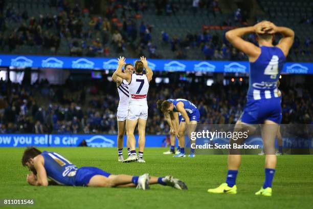 Nat Fyfe of the Dockers celebrates at the final siren as Kangaroos players look dejected during the round 16 AFL match between the North Melbourne...