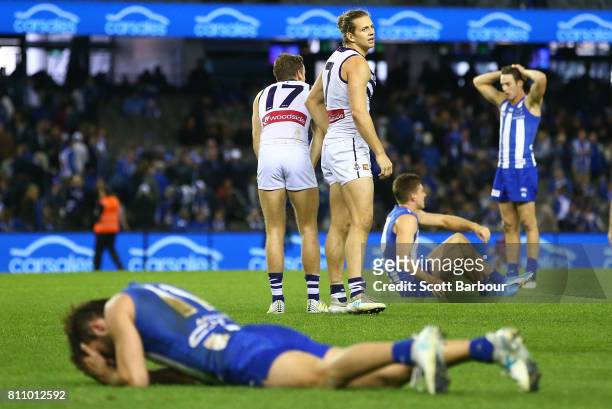 Nat Fyfe of the Dockers celebrates at the final siren as Kangaroos players look dejected during the round 16 AFL match between the North Melbourne...