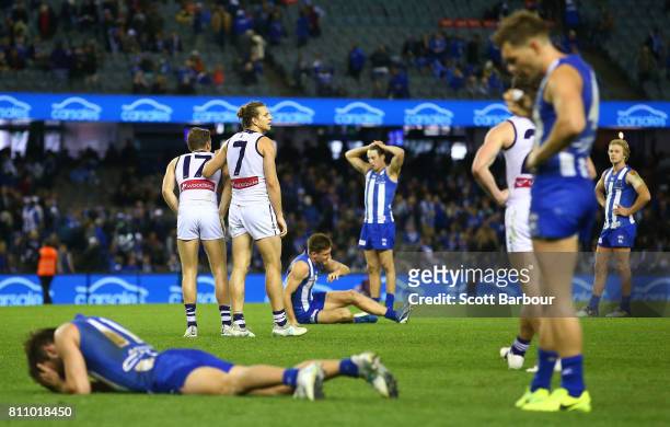 Nat Fyfe of the Dockers celebrates at the final siren as Kangaroos players look dejected during the round 16 AFL match between the North Melbourne...