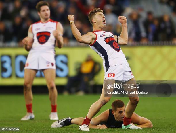 Jake Melksham of the Demons celebrates a goal over Liam Jones of the Blues in the dying stages during the round 16 AFL match between the Carlton...