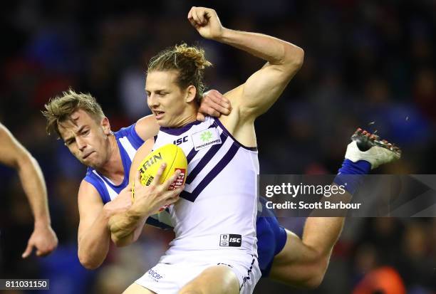 Nat Fyfe of the Dockers is tackled by Trent Dumont of the Kangaroos during the round 16 AFL match between the North Melbourne Kangaroos and the...