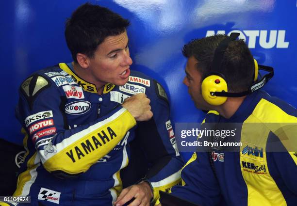 James Toseland of Great Britain and Tech 3 Yamaha chats to a team member during first practice for the MotoGP of France at the Le Mans Circuit on May...