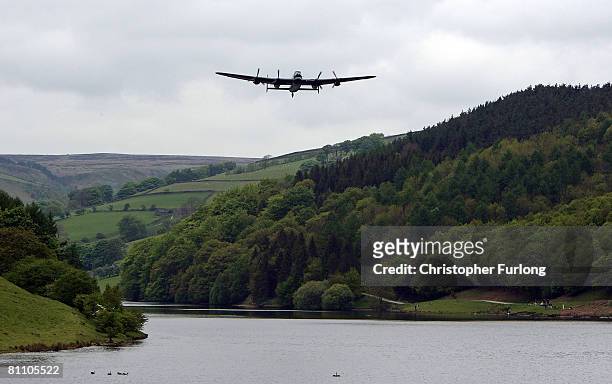 Lancaster bomber flies over Ladybower reservoir in the Derbyshire Peak District to mark the 65th anniversary of the World War II Dambusters mission...