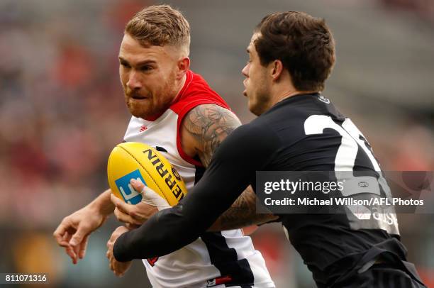 Dean Kent of the Demons is tackled by Lachie Plowman of the Blues during the 2017 AFL round 16 match between the Carlton Blues and the Melbourne...