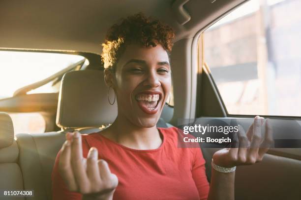 gelukkig lachend young duizendjarige gemengd zwarte vrouw zingen in auto - met de vingers knippen stockfoto's en -beelden