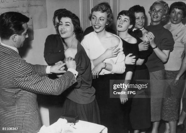 Members of the Association of French Models line up for their smallpox vaccinations, 2nd October 1955.