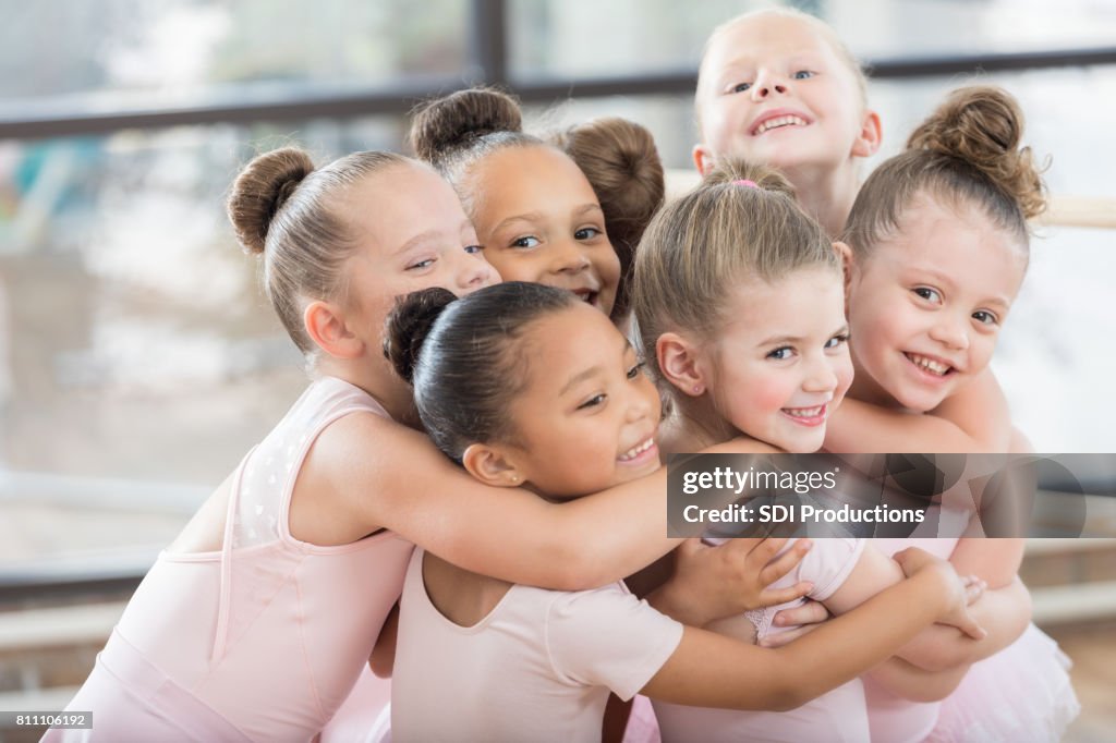 Jóvenes bailarinas forman un sonriente abrazo de grupo