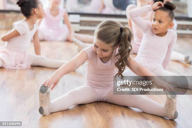 colegas e jovem bailarina estendem as pernas - leotard and tights - fotografias e filmes do acervo