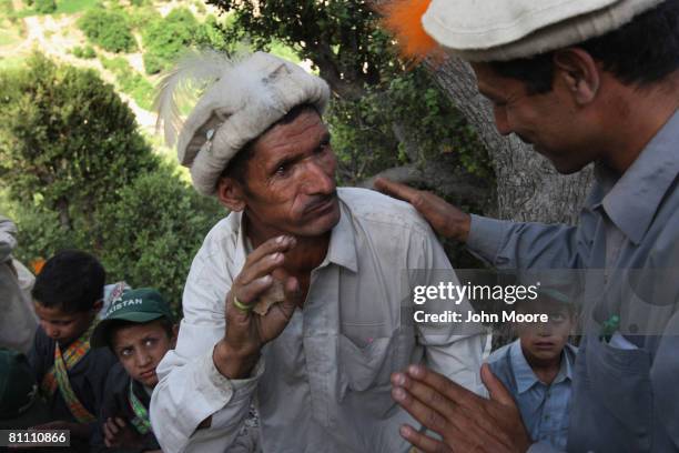 An allegedly intoxicated man is steadied at the Joshi spring festival May 15, 2008 in the remote Chitral village of Rumbur in northwestern Pakistan....