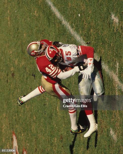 Wide receiver Shawn Collins of the Atlanta Falcons is drilled by safety Ronnie Lott of the San Francisco 49ers in Atlanta Fulton-County Stadium on...