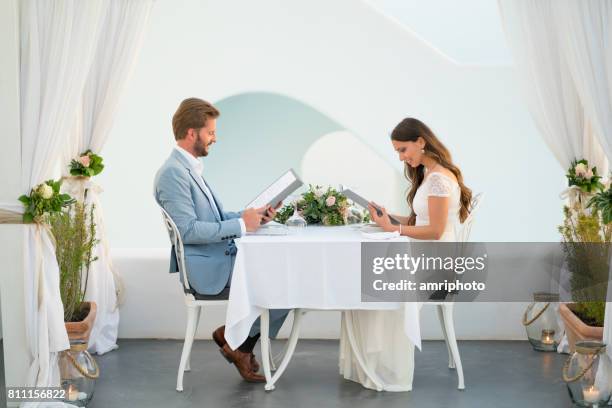 paar lezen het menu in een romantische setting vakantie huwelijksreis - tafel voor twee stockfoto's en -beelden